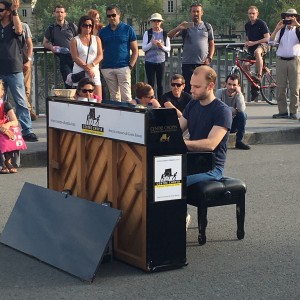 Man playing piano on bridge over the Seine