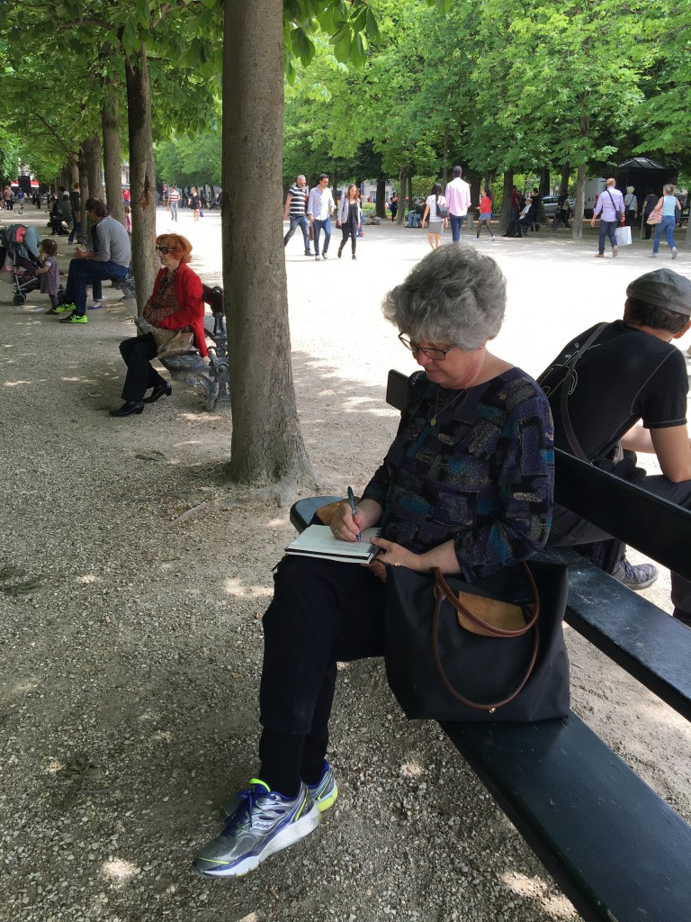 Woman on a bench in a park writing in her journal