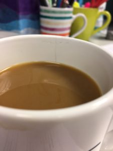 Close up photo of a cracked coffee cup sitting on office desk