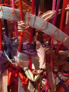 Close up of a finished section of a weaving in progress at the Columbus Museum of Art. Bright colors and a variety of materials